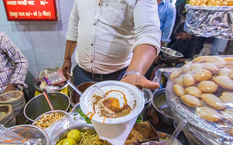 ظرف بهالا در دست آشپزی در میان غذاهای خیابانی آگرا ظرف بهالا در دست آشپزی در میان غذاهای خیابانی آگرا