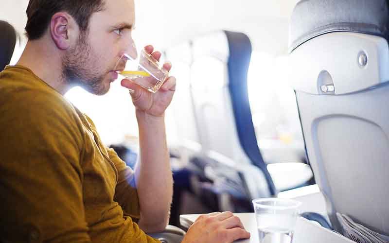 happy-man-seating-in-the-aircraft-and-drinking-water-before-his-trip-abroad-800x500.jpg